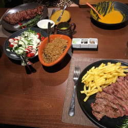 Black Angus steak with salad and rice on top. Royal steak with french fries on bottom.