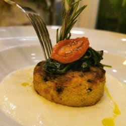 Tortino di patate e spinaci su un letto fi crema al parmigiano 