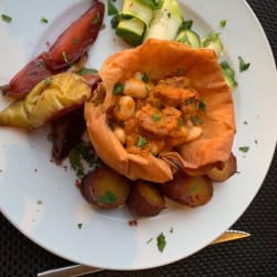 Cesto grego de feijoca estufada com batata doce aromatizada e pera bebeda em cama de courgette